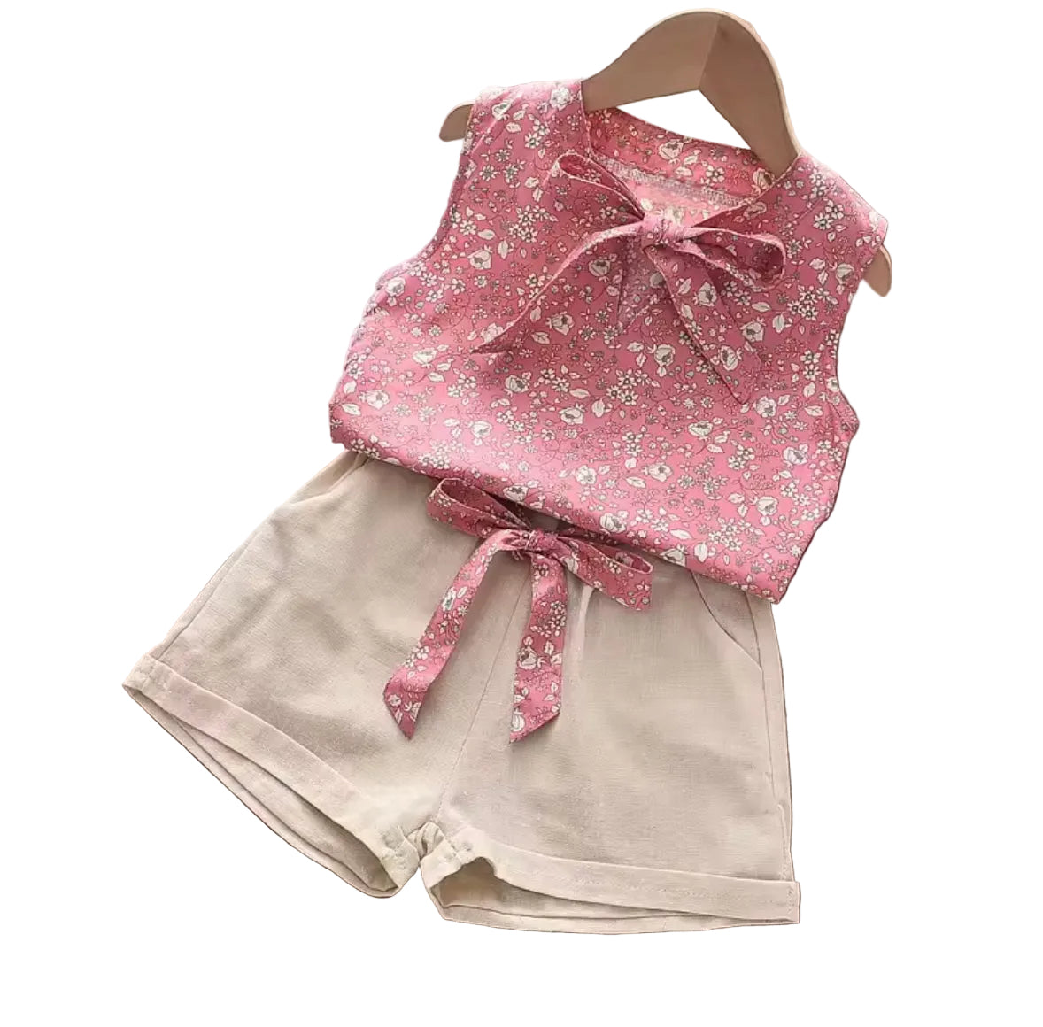 Pink floral top with a bow and beige shorts on a white background