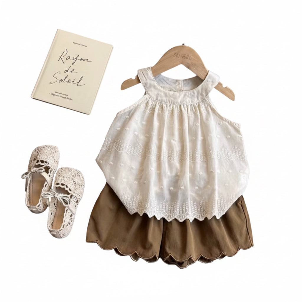 Children's white top and brown skirt with shoes on a wooden table
