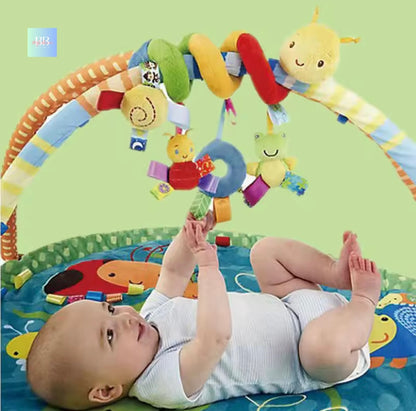 Baby playing with a colorful baby gym on a green background