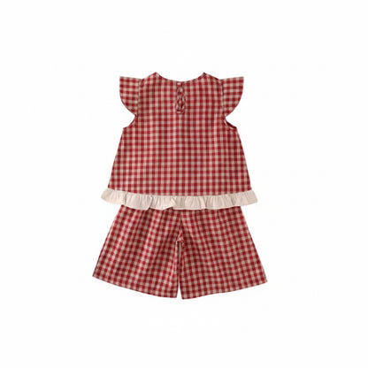 Red and white checkered outfit with ruffled top and shorts on a light beige background
