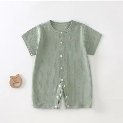 Green baby romper with buttons on a white background