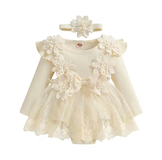 Cream-colored baby dress with floral details and matching headband on a white background