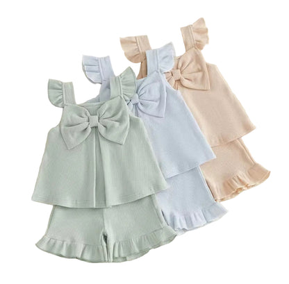 Children's outfit with a bow top and shorts on a light background