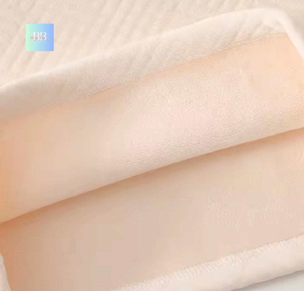 Close-up of beige fabric texture with a brand logo in the corner.