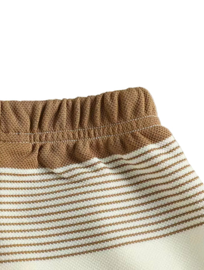 Close-up of brown and white striped fabric with a plain background