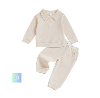 Beige baby outfit with shirt and pants on a white background