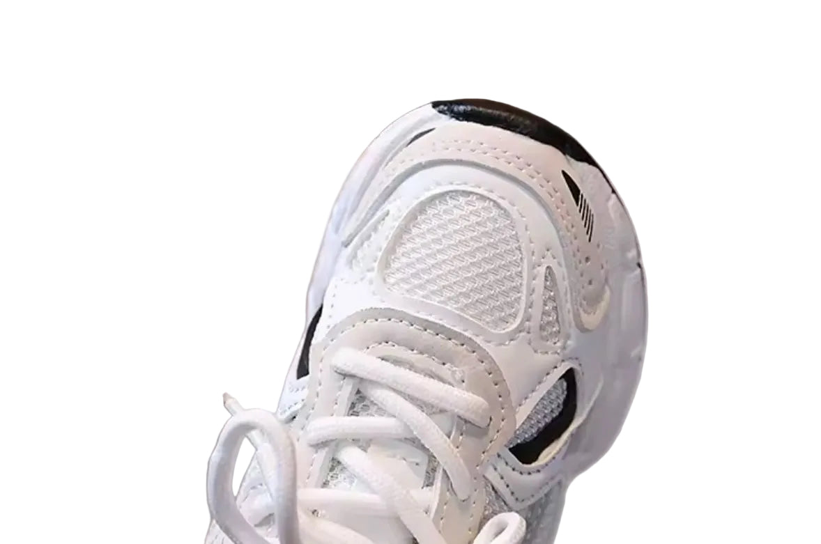 White sneaker with black accents on a reflective surface