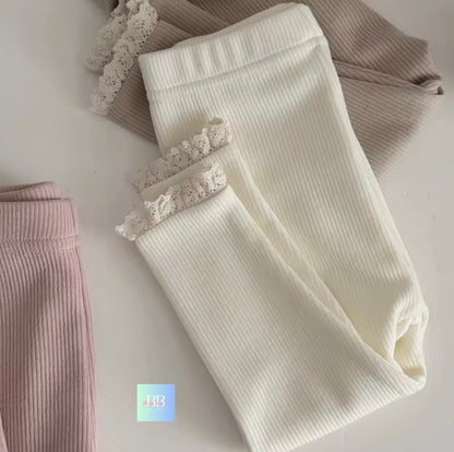 White ribbed leggings with lace trim on a light gray background