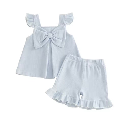 White baby dress with bow and ruffled shorts on a white background