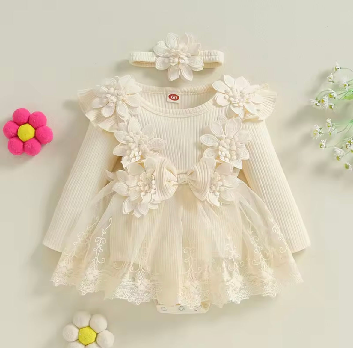 White floral dress with long sleeves and matching headband on a light background