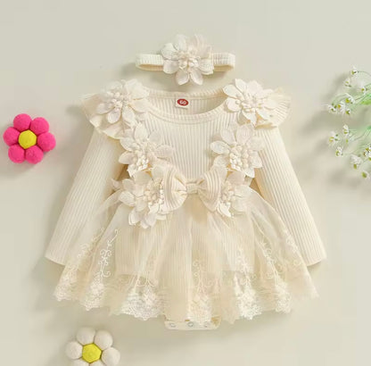 White floral dress with long sleeves and matching headband on a light background