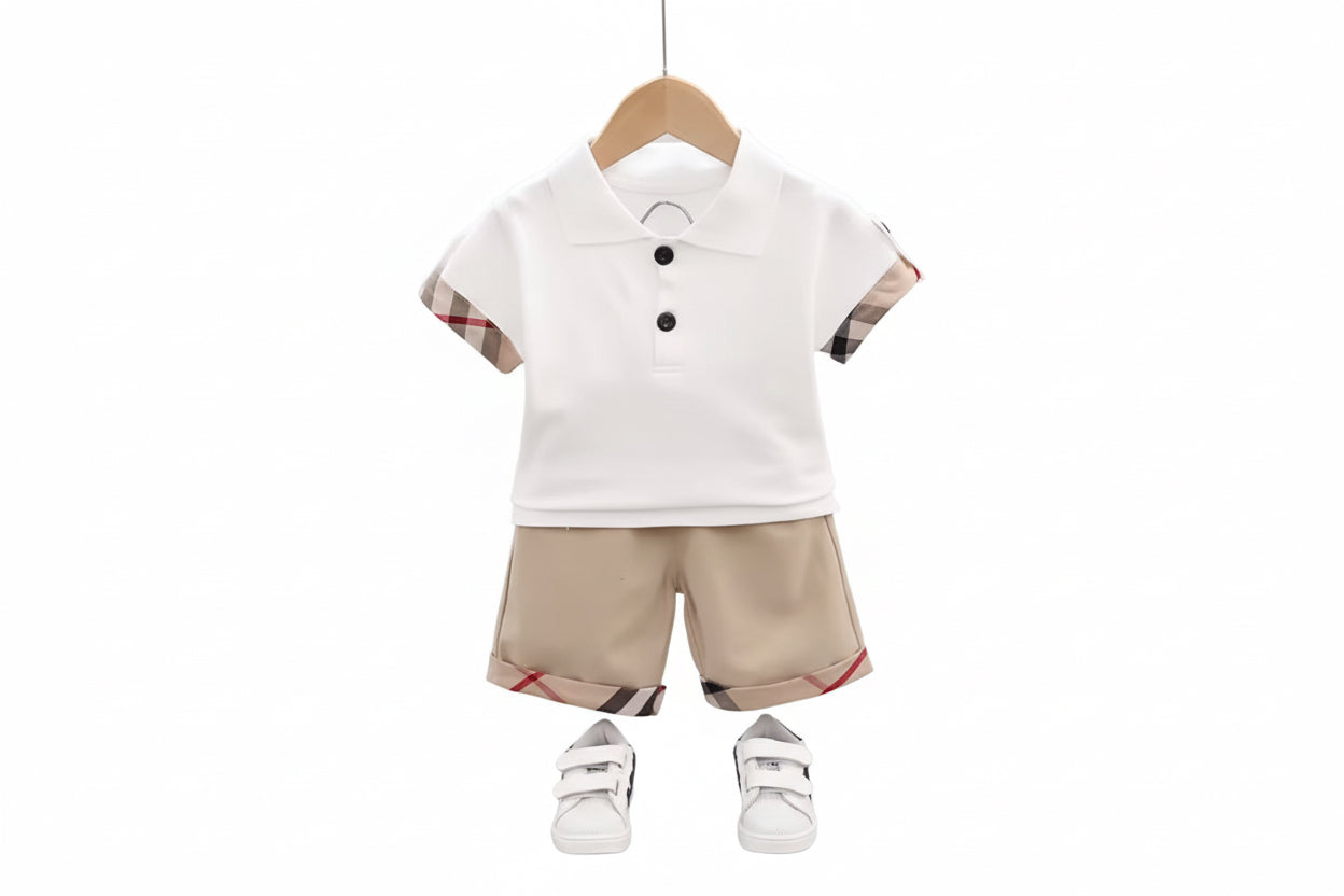 Children's outfit with white polo shirt and beige shorts on a hanger against a light gray background.