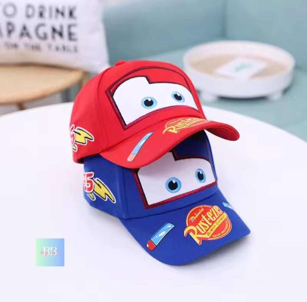 Red and blue children's cap with cartoon design on a white surface