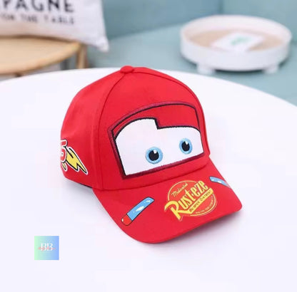 Red children's cap with cartoon face design on a white surface