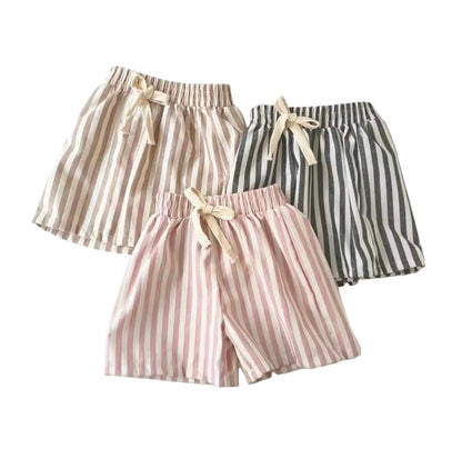 Three pairs of striped shorts in pink, white, and black on a light background