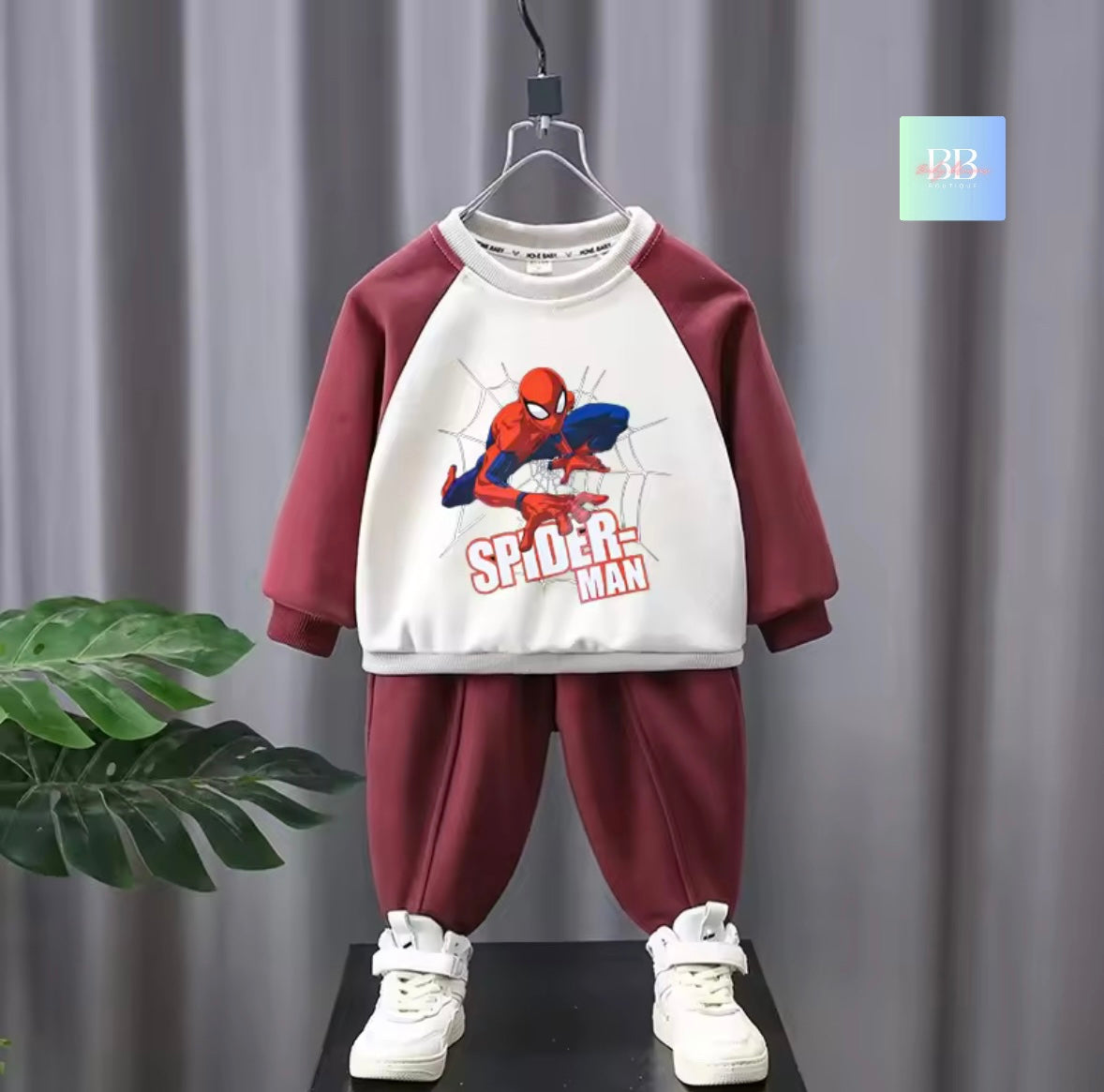 Children's Spider-Man outfit on a hanger against a gray curtain background