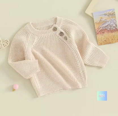Knitted baby sweater with buttons on a light background