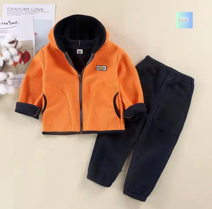 Orange fleece jacket and black pants on a light background