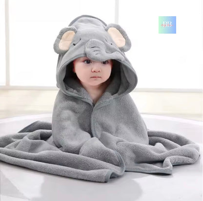 Child wearing a gray elephant hooded towel on a white surface
