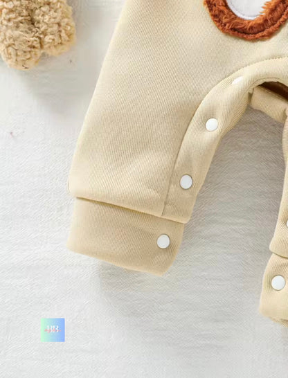 Close-up of a beige baby outfit with buttons on a white background