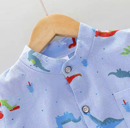 Children's shirt with dinosaur pattern on a wooden hanger against a light gray background