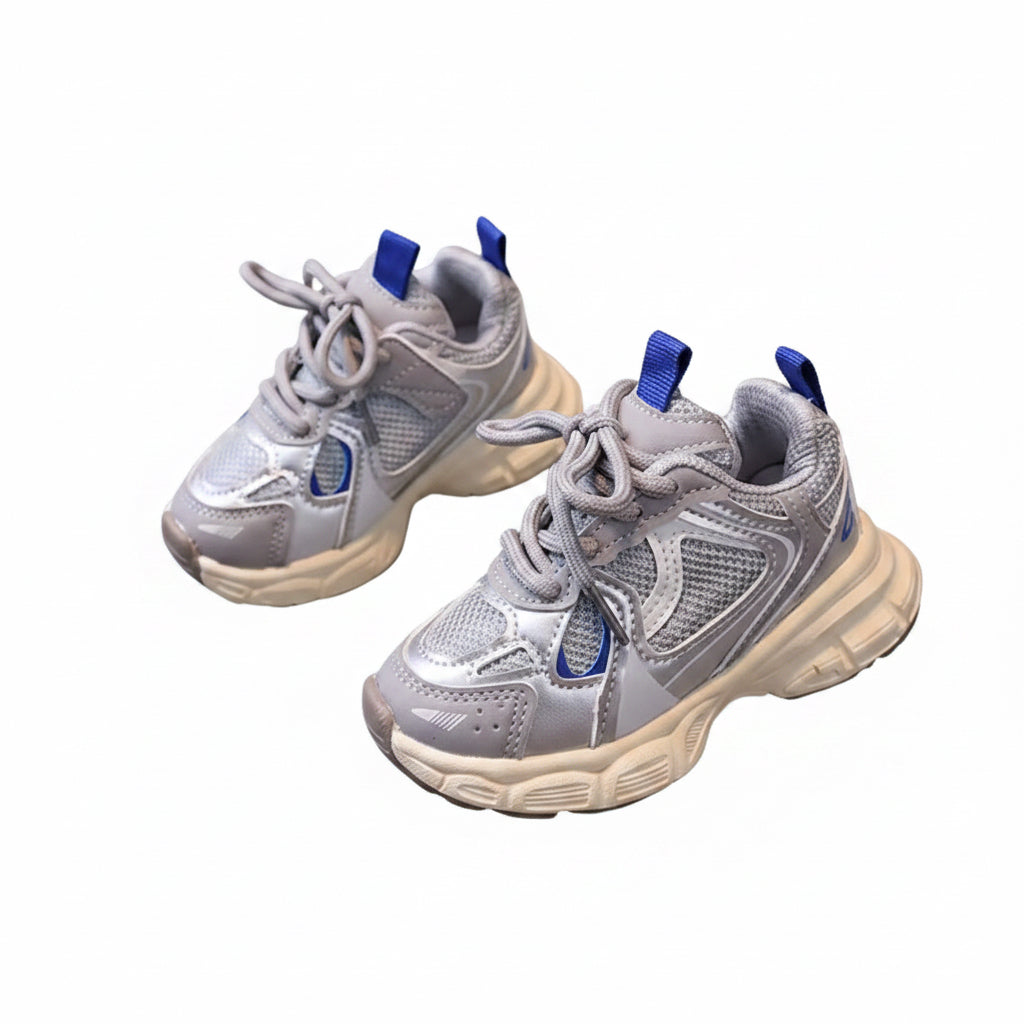 Pair of gray sneakers with blue laces on a round surface.
