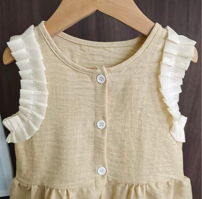 Beige dress with white ruffled sleeves on a wooden hanger against a dark background