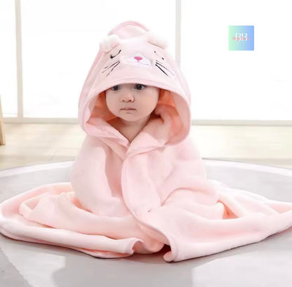 Child wearing a pink hooded towel with cat ears on a light background