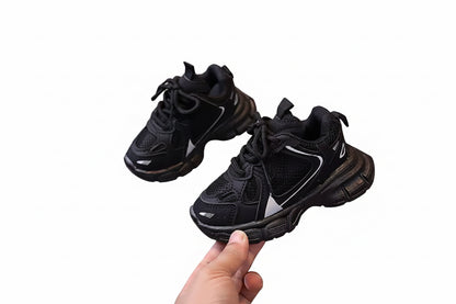 Black sneakers on a white surface with a blurred background
