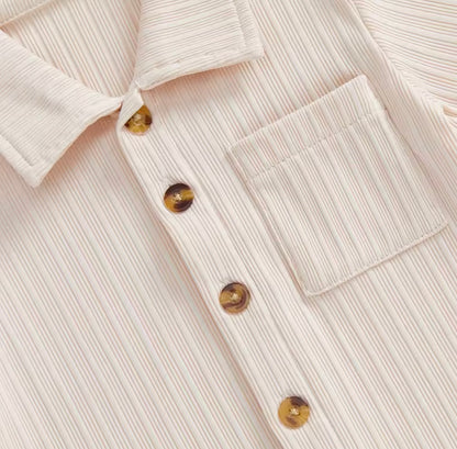 Close-up of a beige ribbed sweater with button details