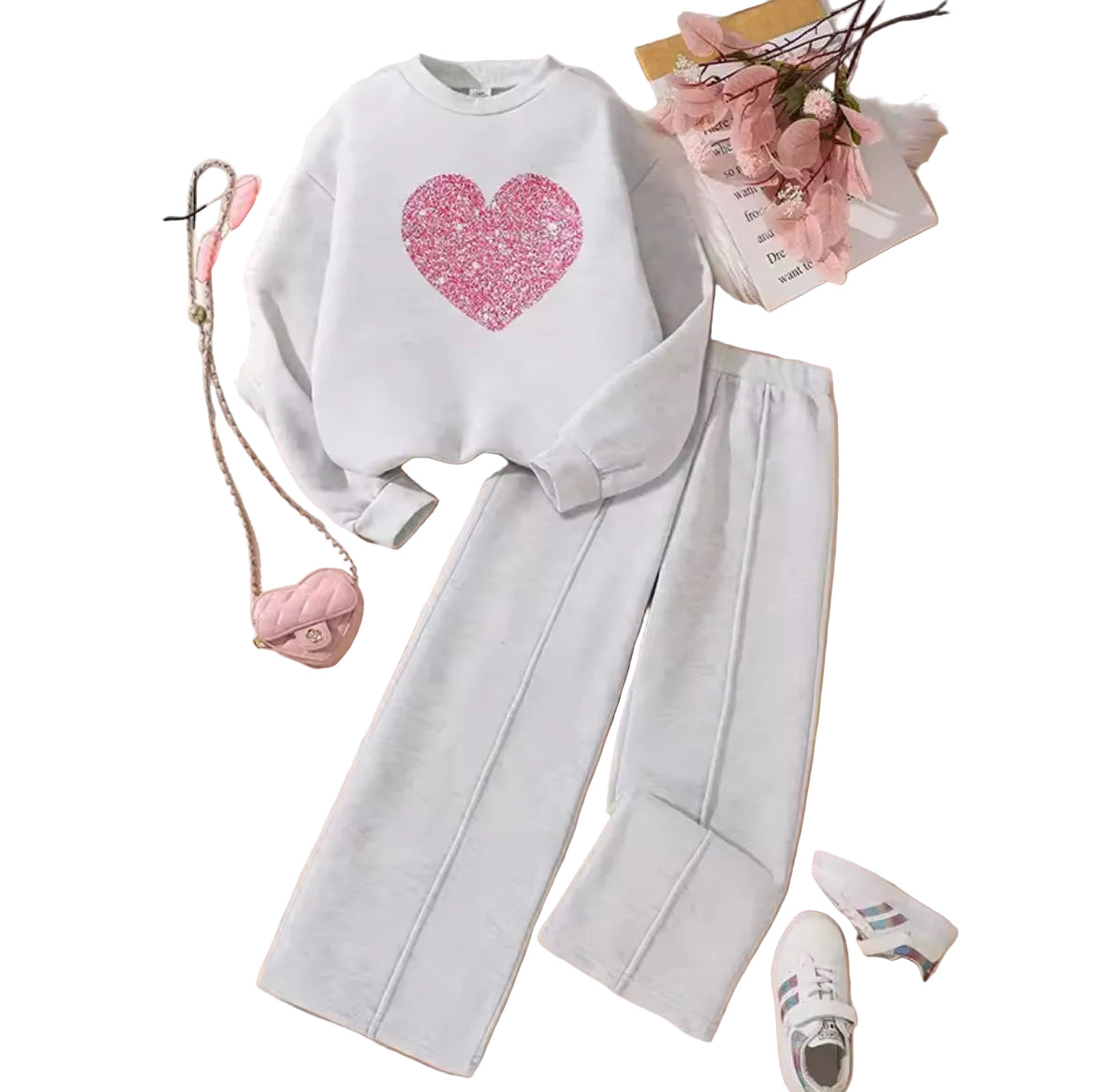 White sweatshirt with pink heart design and gray pants on a wooden surface.