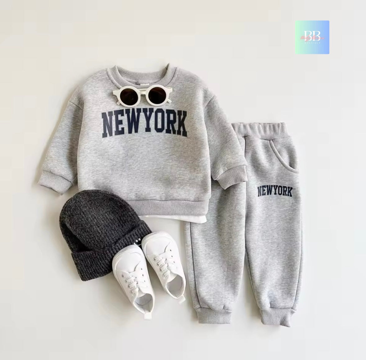 Gray 'New York' sweatshirt and pants set with a beanie and sneakers on a white background