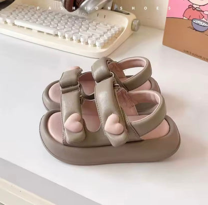 Pair of children's sandals on a desk with a keyboard in the background