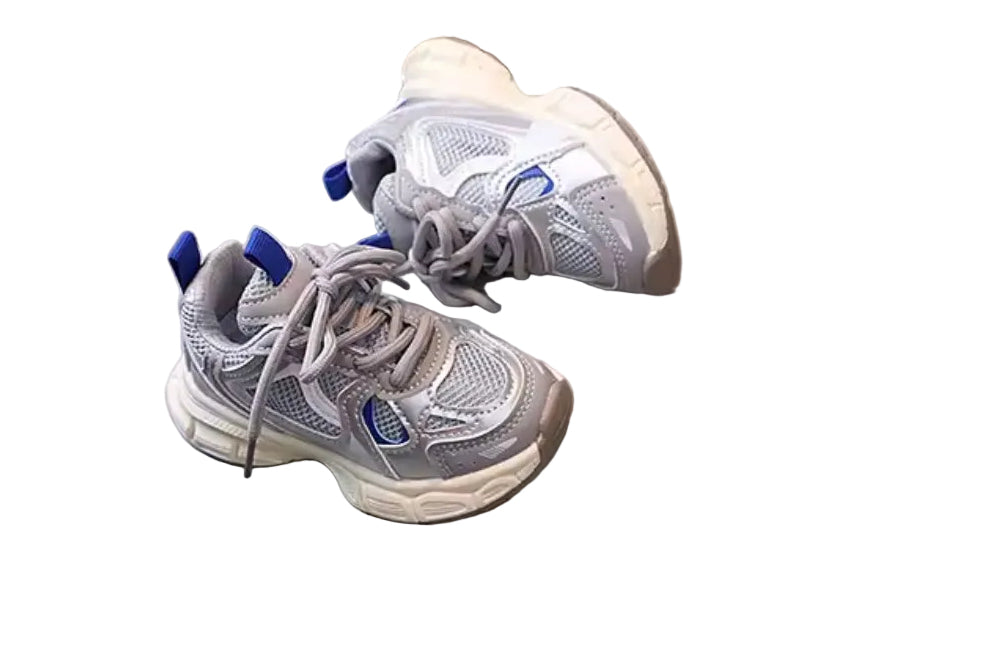 Pair of gray sneakers with blue accents on a round surface with a wooden floor background