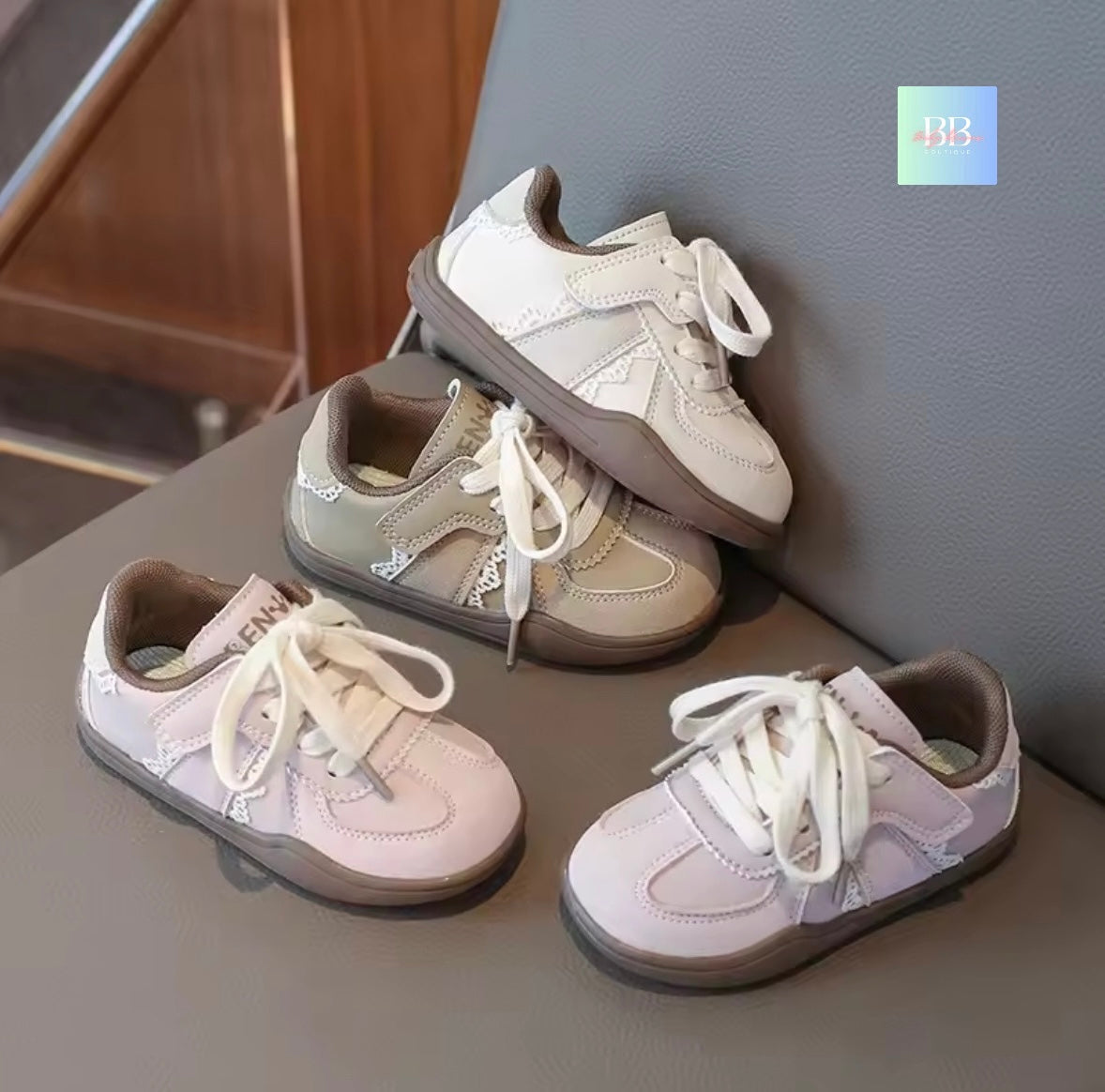 Set of children's sneakers on a surface with a neutral background