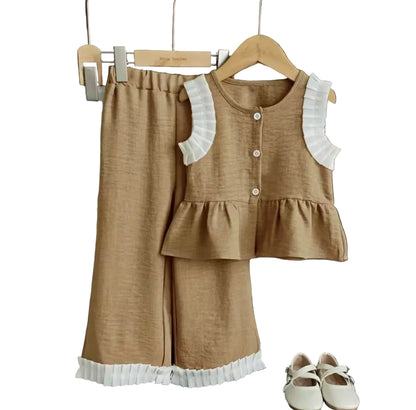 Children's brown outfit with ruffled details on a wooden hanger against a dark background.