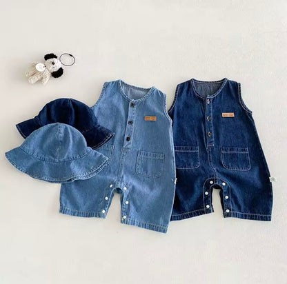 Two denim baby rompers and a hat on a light gray background