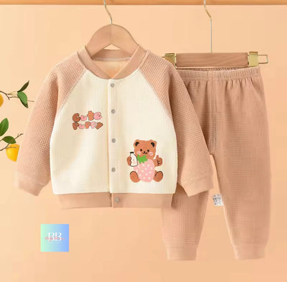 Children's outfit with jacket and pants on a hanger against a beige background