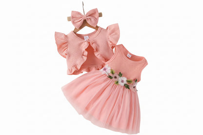 Pink children's dress with floral details, matching headband, and white shoes on a light background.