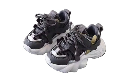 Pair of black and white sneakers on a gray surface with a blurred background