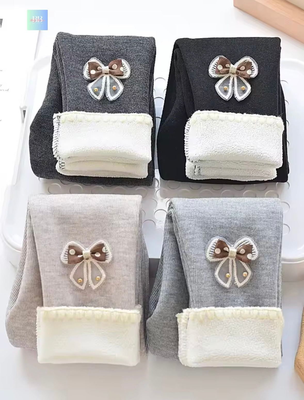 Four pairs of socks with bow designs on a white background