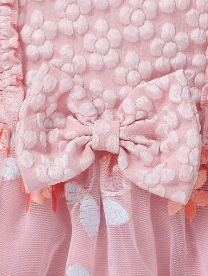 Close-up of a pink textured fabric with a bow and floral details