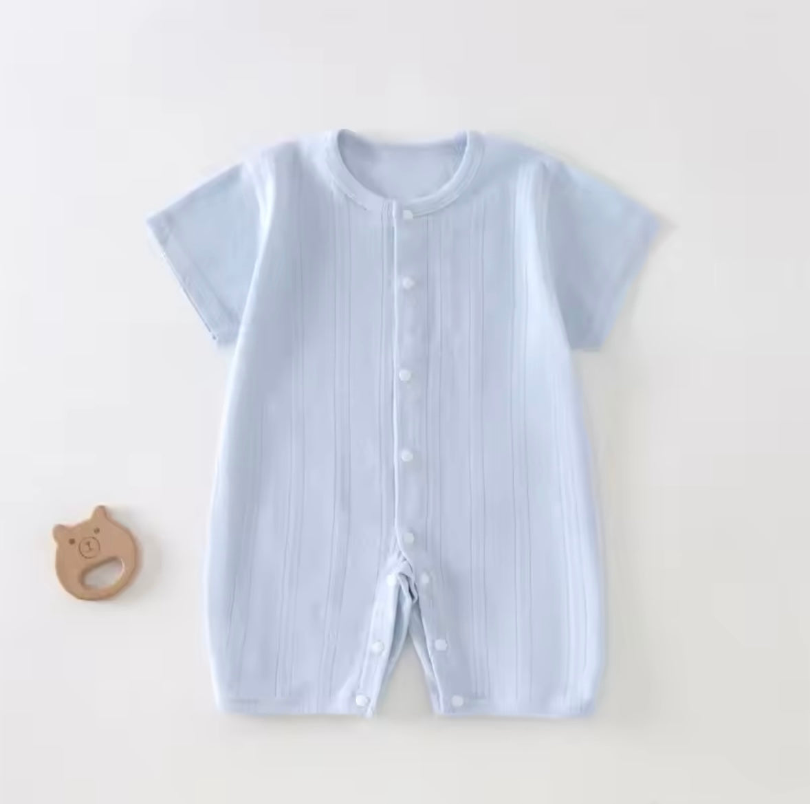 Light blue baby romper with buttons on a white background