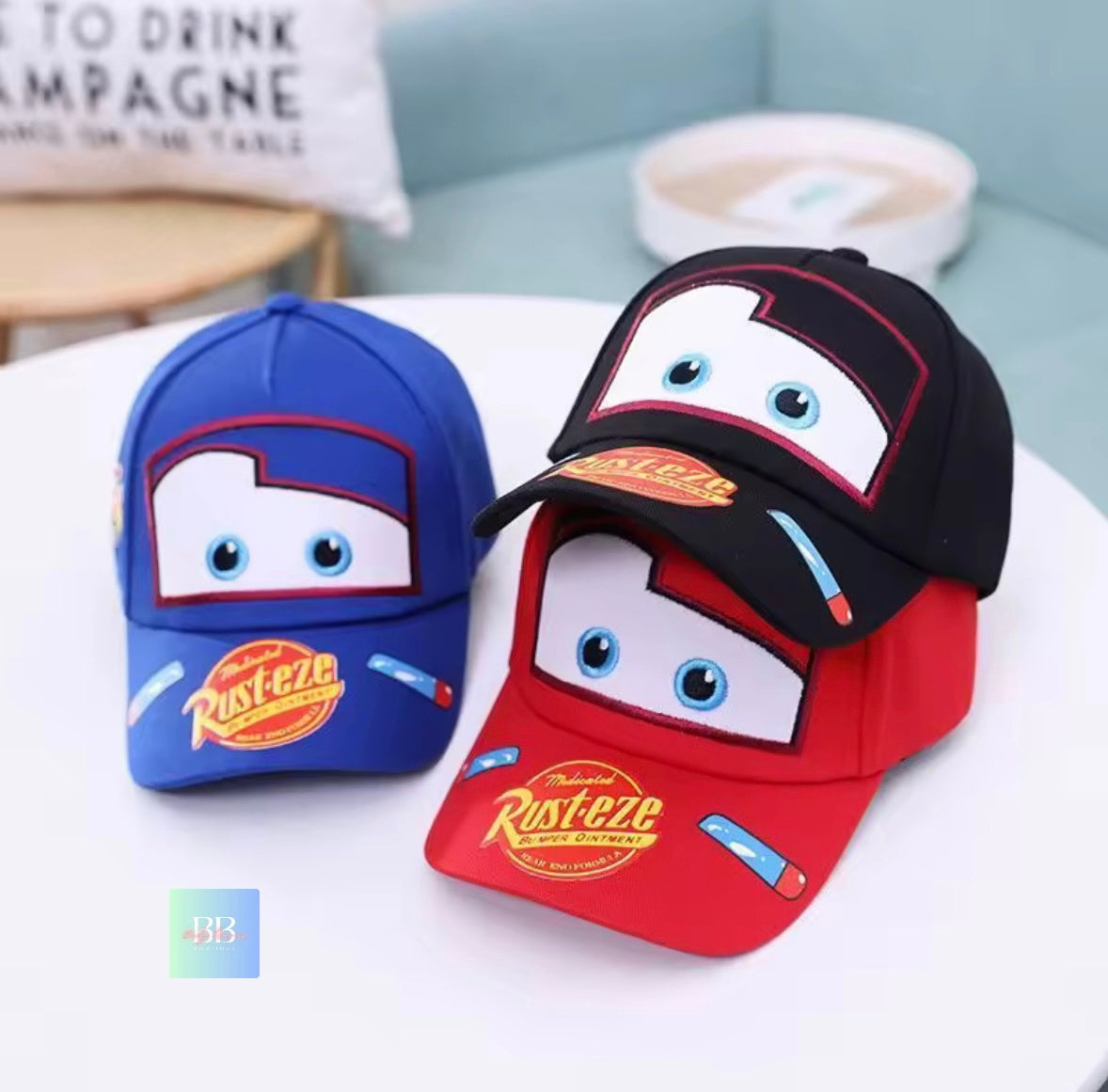 Two children's baseball caps with cartoon face design on a white surface.