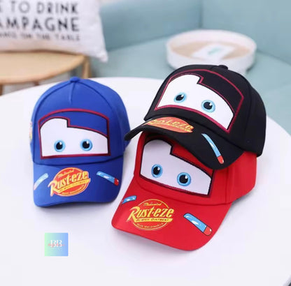 Two children's baseball caps with cartoon face design on a white surface.