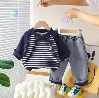 Children's outfit with navy and white striped shirt, gray pants, and green sneakers on a hanger.
