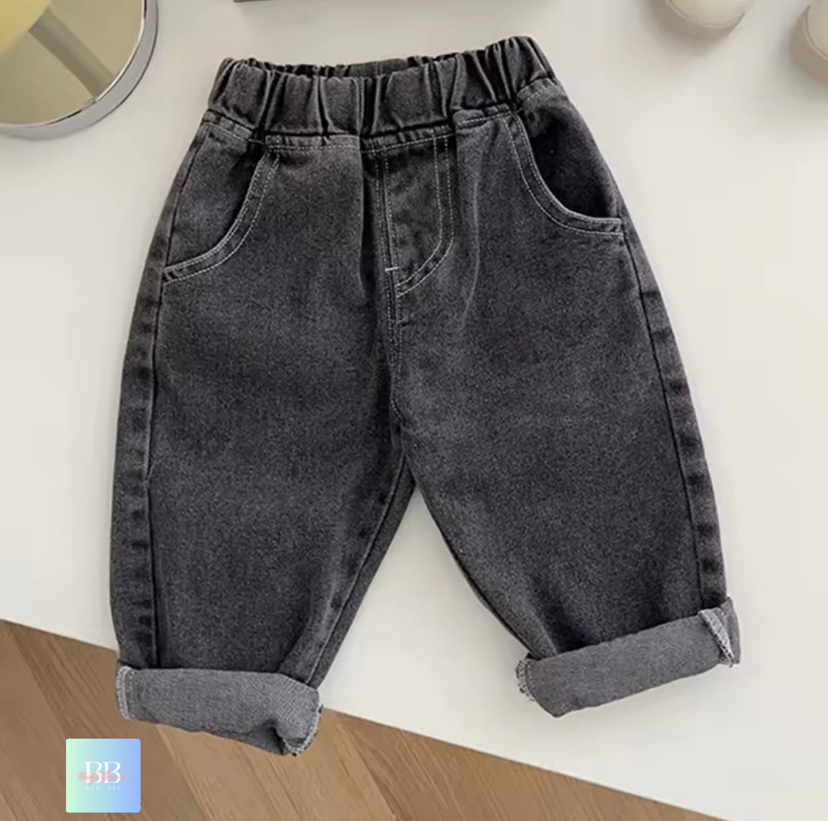 Gray denim pants on a white surface