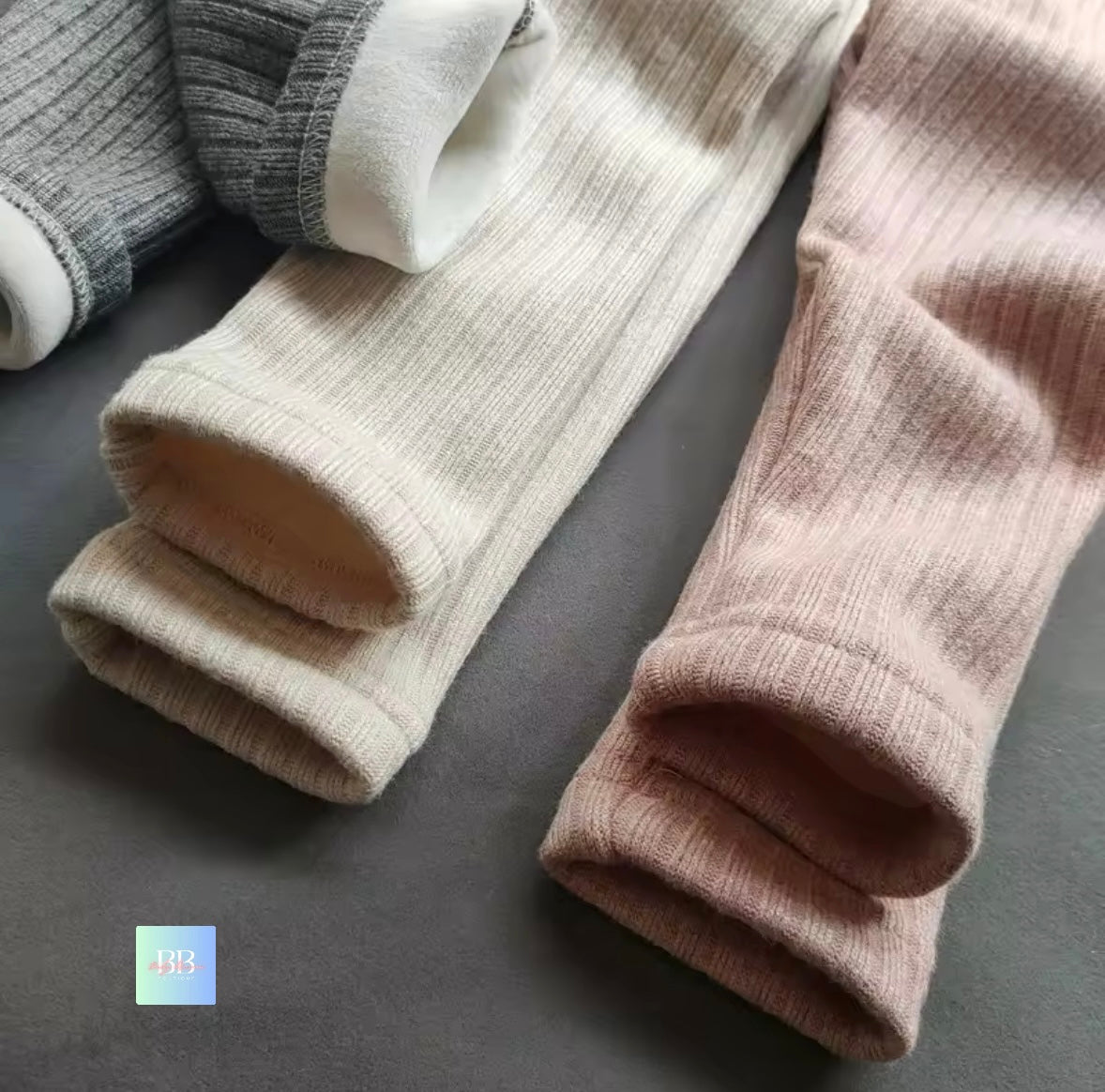 Three pairs of socks in different colors on a dark surface