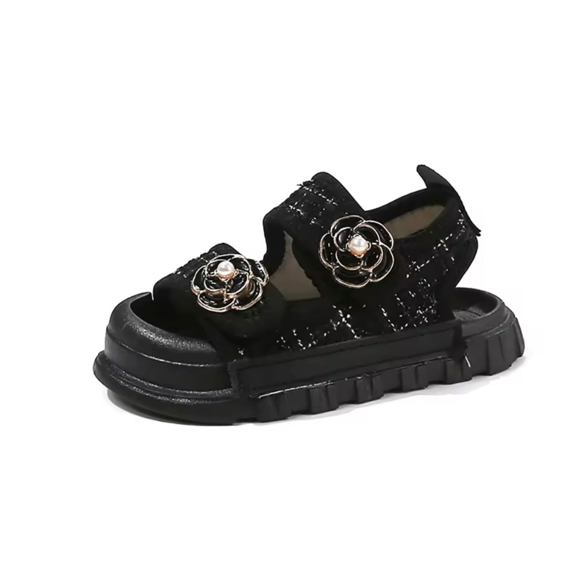 Black sandal with floral embellishments on a white background
