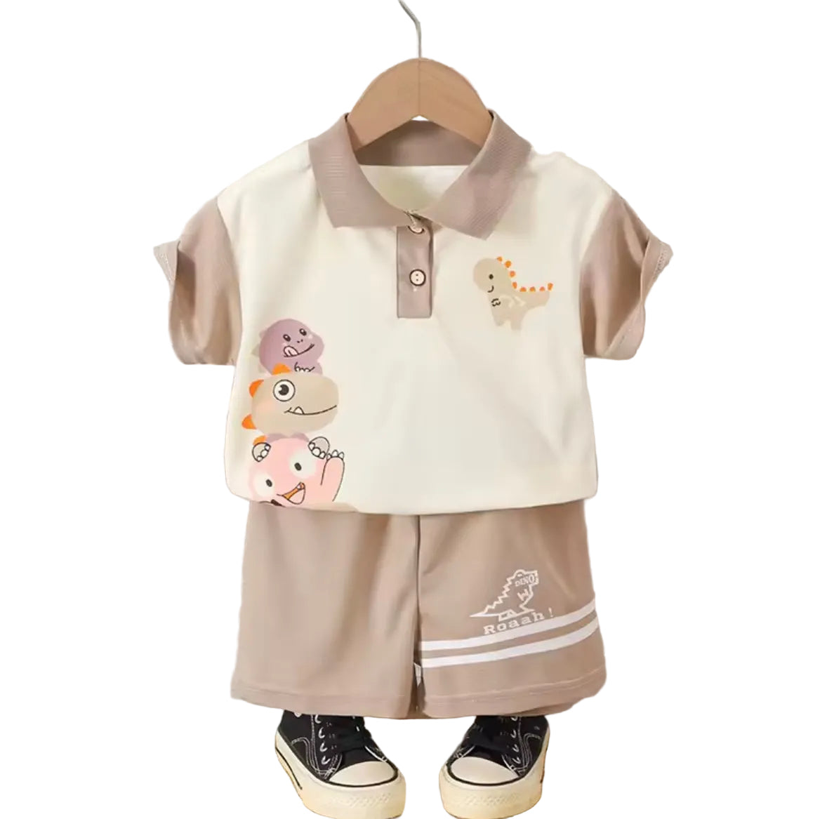 Children's outfit with cartoon designs on a hanger against a neutral background